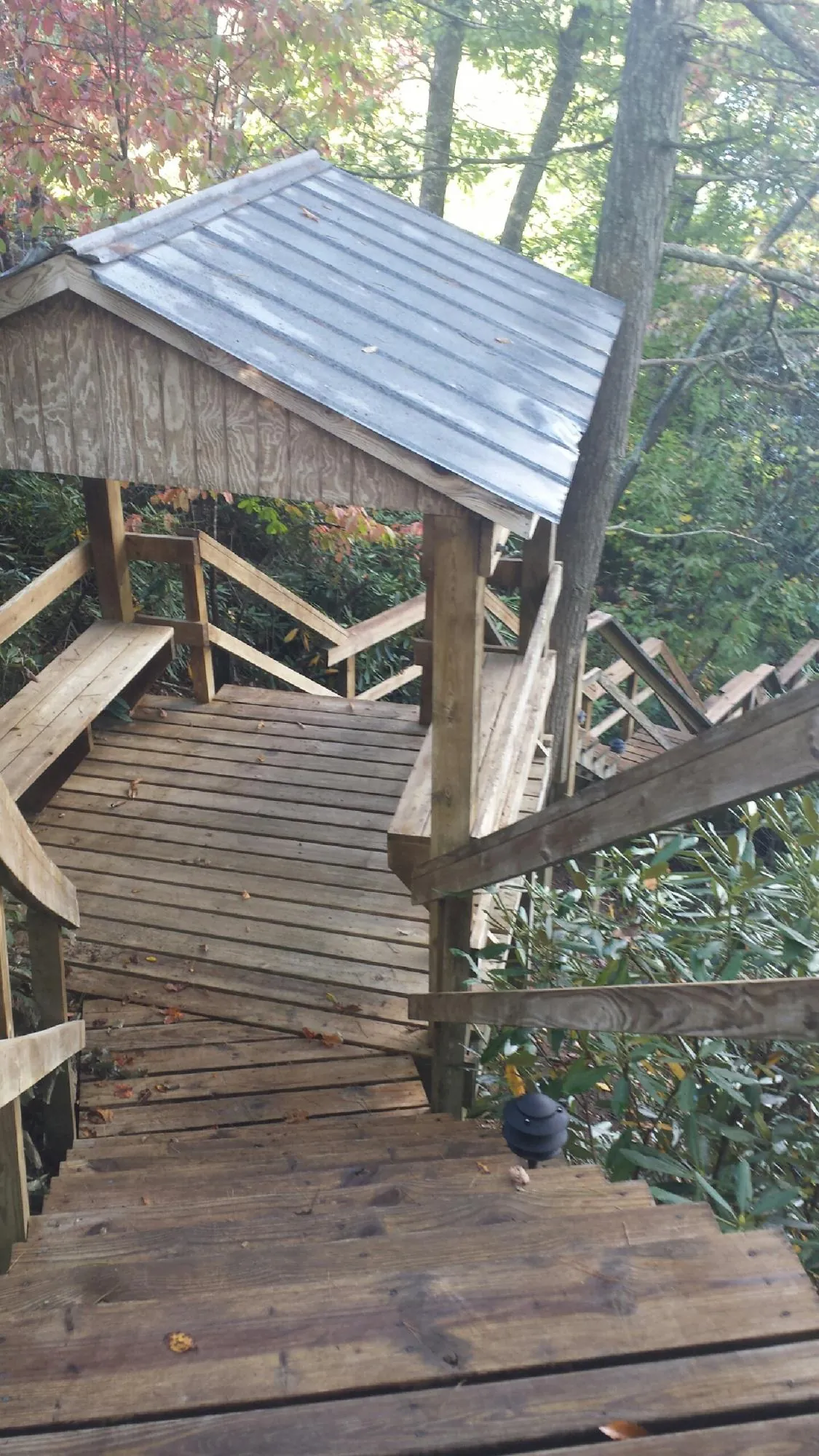 Metal roofed shelter over wooden steps on a wooded walkway — Skylight Repair & Installation work by our crew in Leonardsville